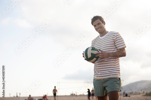 Fototapeta Naklejka Na Ścianę i Meble -  Young man with ball at the beach. Handsome man playing volleyball.