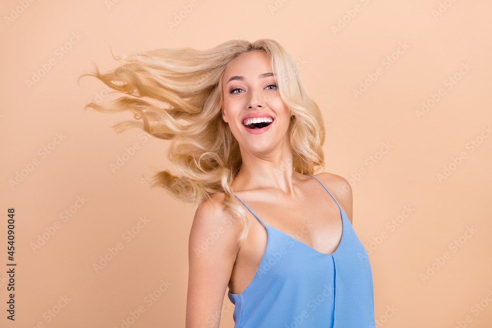 Photo of young attractive woman happy positive smile fly air wind hair isolated over beige color background Photo of young attractive woman happy positive smile fly air wind hair isolated over beige color background