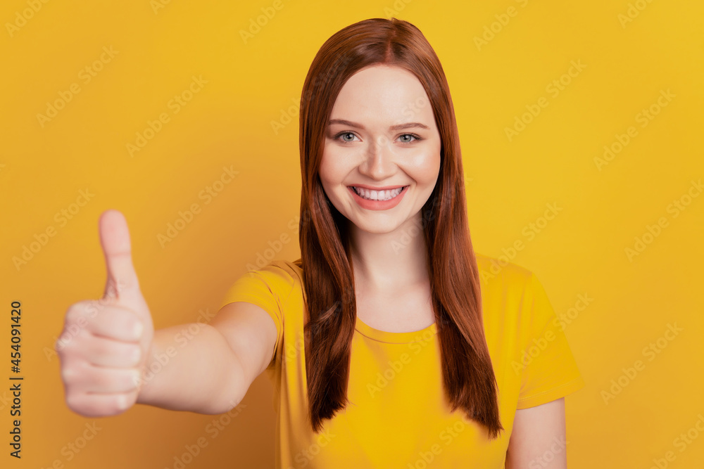 Beautiful young woman give thumb up isolated on yellow background Beautiful young woman give thumb up isolated on yellow background