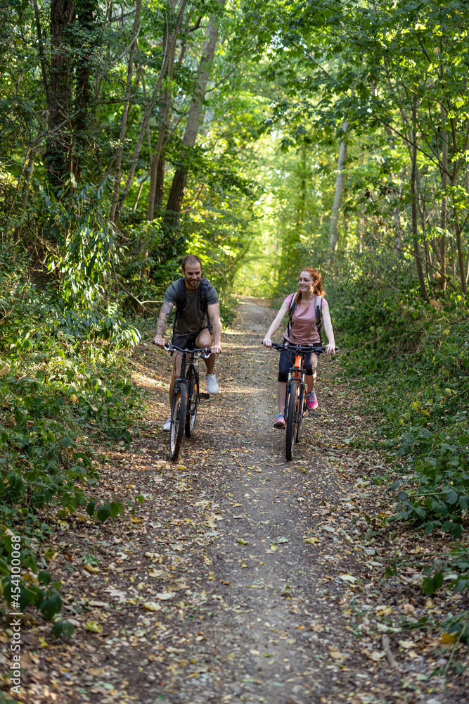 Young couple cycling in forest Young couple cycling in forest