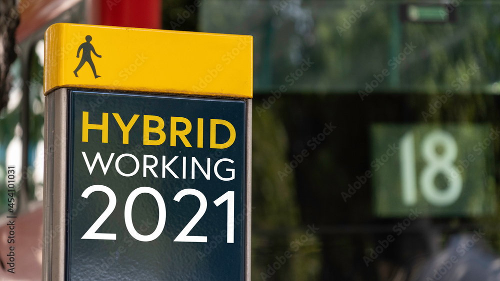 Hybrid Working 2021 sign in a busy commuter city center Hybrid Working 2021 sign in a busy commuter city center