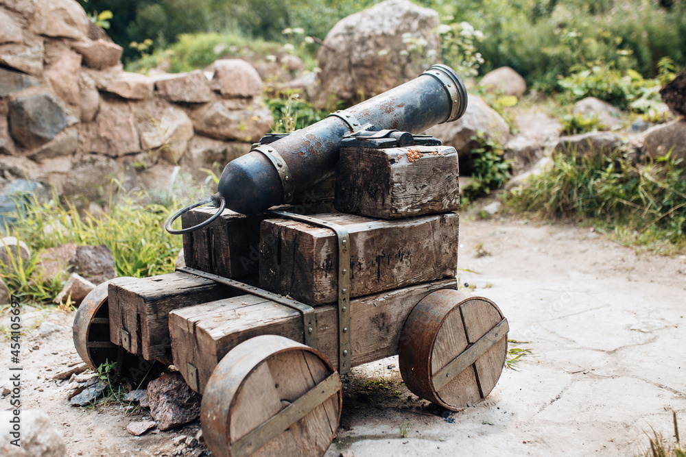 Ancient cannon with a cast iron barrel for shooting cannonballs - weapon reconstruction Ancient cannon with a cast iron barrel for shooting cannonballs - weapon reconstruction