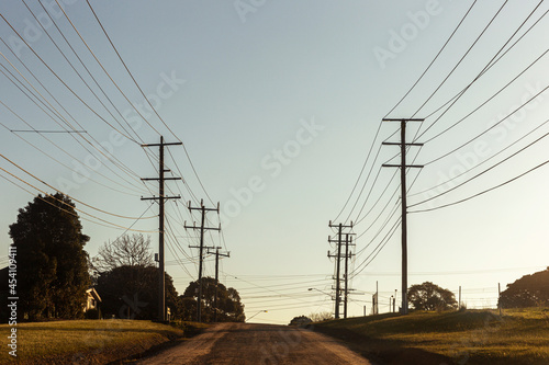 Electric poles and cables along country road.