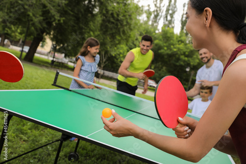 Happy families playing ping pong in park