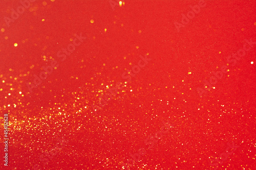 Small gold glitter on bright red background