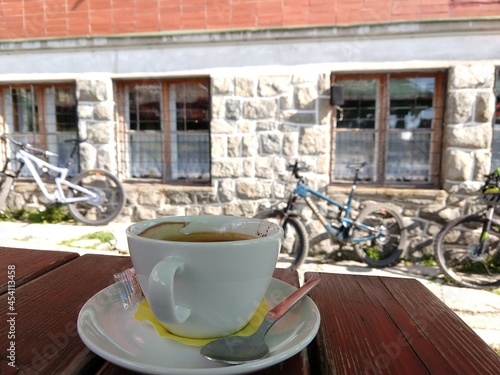 Espresso coffee on the table with bicycles on the background near challet. Slovakia