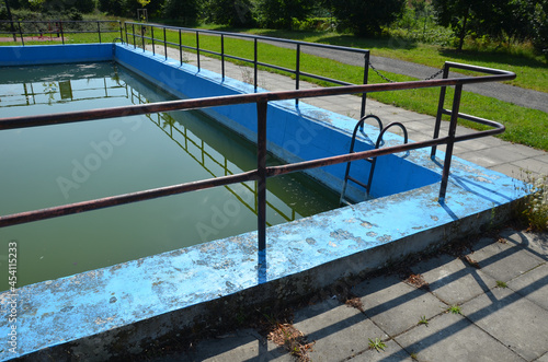 an old half-empty concrete pool on each square. It has railings and steps made of metal. Water is used by firefighters against fire. It is not hygienically clean for bathing and swimming