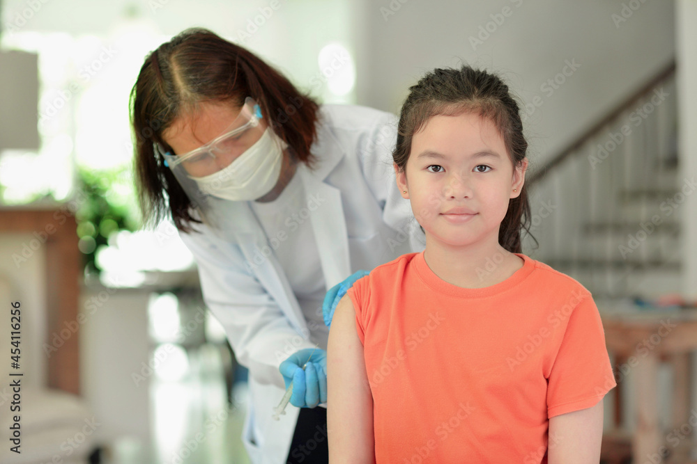 Obraz premium Asian child being vaccinated.Children vaccination by nurse.Medical doctor vaccinating school student in the arm.Paediatrician administrating vaccine to students in clinic.Physician injecting person.