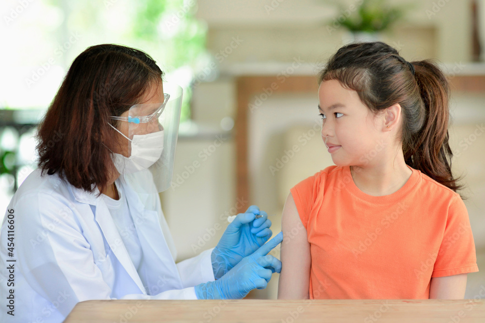 Obraz premium Asian child being vaccinated.Children vaccination by nurse.Medical doctor vaccinating student in the arm.Paediatrician administrating vaccine to students in clinic.Physician injecting young person.