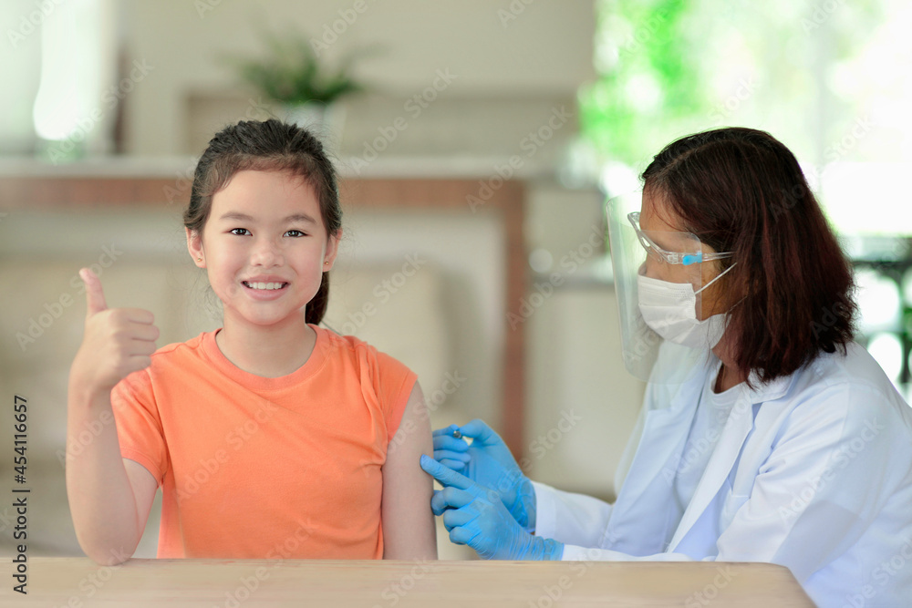 Asian child being vaccinated.Children vaccination by nurse.Medical doctor vaccinating school student in the arm.Paediatrician injecting vaccine to students in clinic.Girl thumb up. Asian child being vaccinated.Children vaccination by nurse.Medical doctor vaccinating school student in the arm.Paediatrician injecting vaccine to students in clinic.Girl thumb up.