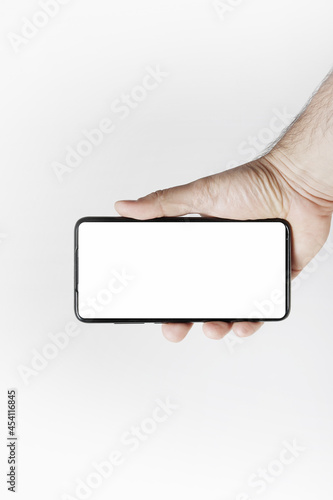 Obraz na płótnie Smartfon w ręce na jasnym tle w salonie
