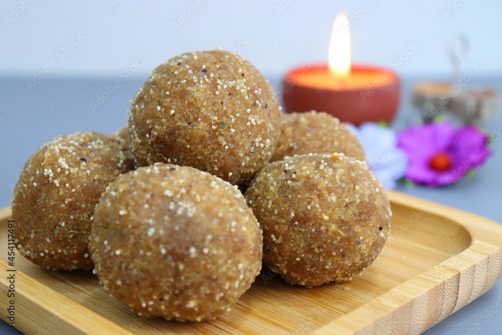Diwali Diya, Sweets or Mithai, and flowers are arranged as a festive background. Churma laddu for Indian festivals, Ganesh Chaturthi. With copy space. Diwali Diya, Sweets or Mithai, and flowers are arranged as a festive background. Churma laddu for Indian festivals, Ganesh Chaturthi. With copy space.
