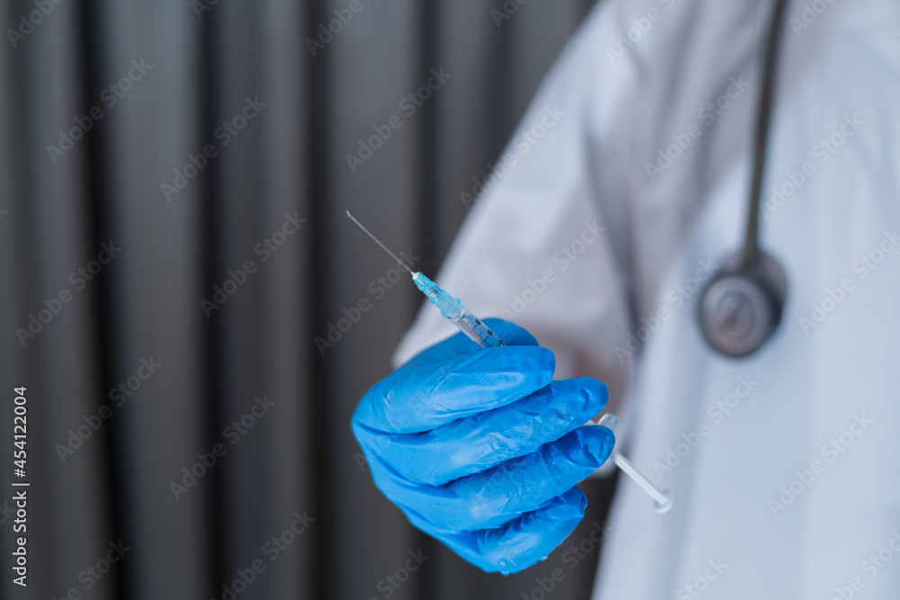 Unrecognizable male doctor holding vaccine syringe, hands wearing protective gloves. Closeup shot of hands holding vaccine syringe isolated from background. Unrecognizable male doctor holding vaccine syringe, hands wearing protective gloves. Closeup shot of hands holding vaccine syringe isolated from background.