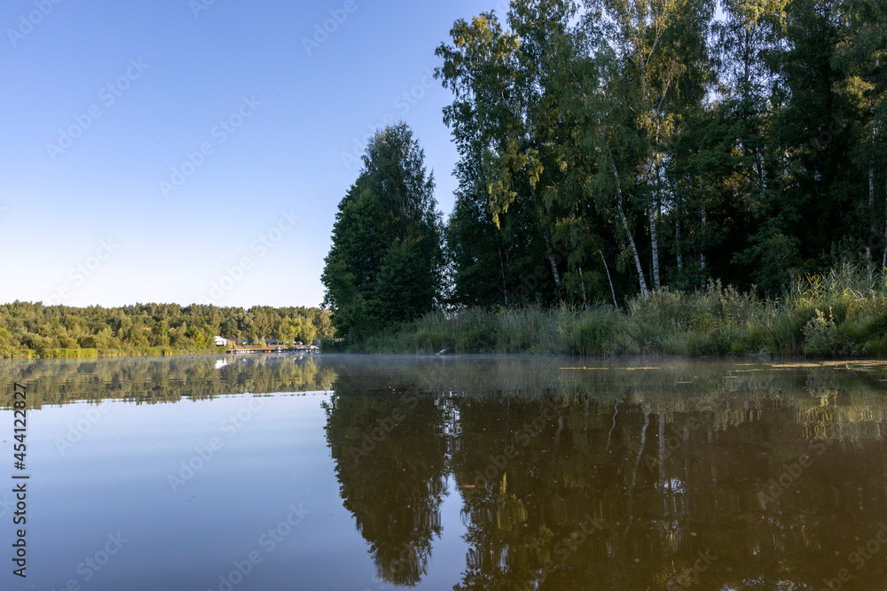Picturesque morning landscape. River trip. The first rays of the sun illuminate the trees and the river.