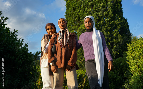 Portrait of three young women wearing hijabs outdoors photo