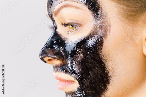 Fototapeta Naklejka Na Ścianę i Meble -  Woman applying black cleanser mask to face