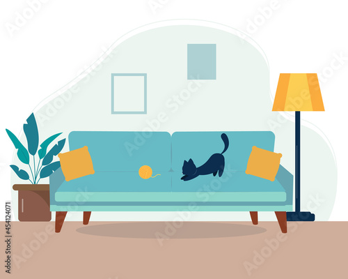Cat playing with yarn on the sofa