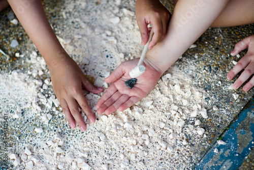Child's hand holding crystal rock.Mining Science activity fot children.Exploration of minerals for kids.Discovery of rocks. © Jeanette Goh