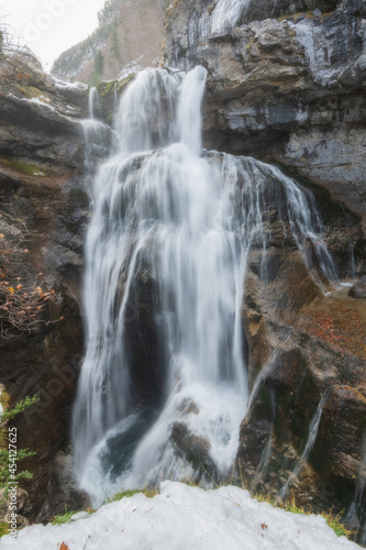 River waterfall in a mountain river landscape in snowy winter  with trees in Ordesa Valley  Pyrenees  national park  Spain. Horizontal view