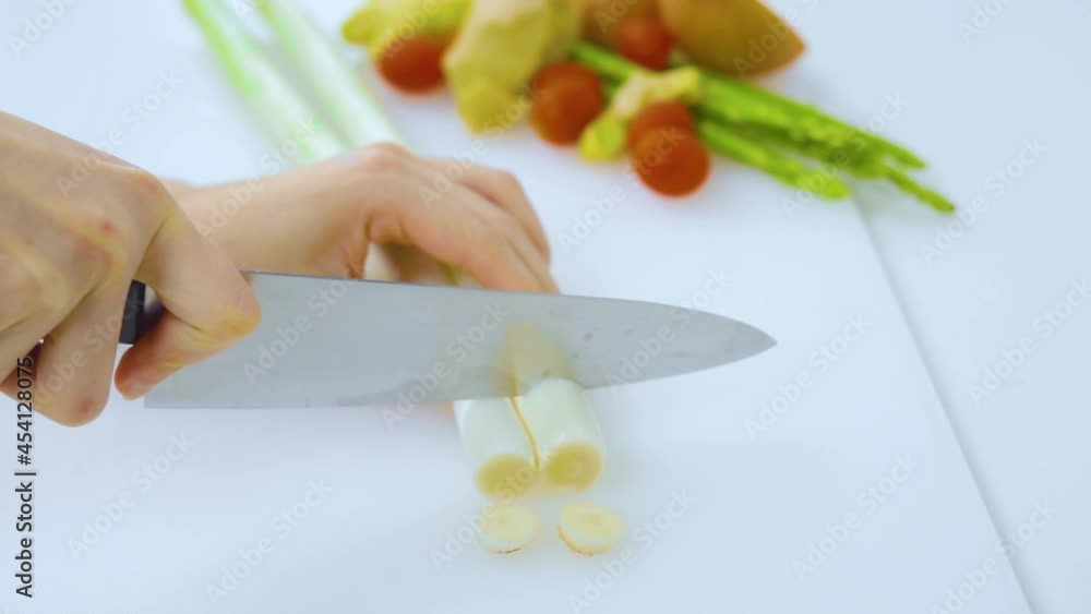 Hands cutting leeks preparing for cooking Hands cutting leeks preparing for cooking