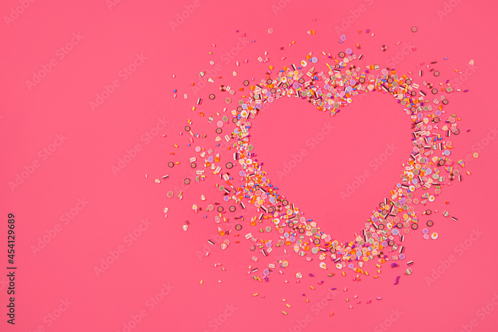 Heart made of confetti on a pink background. Love.