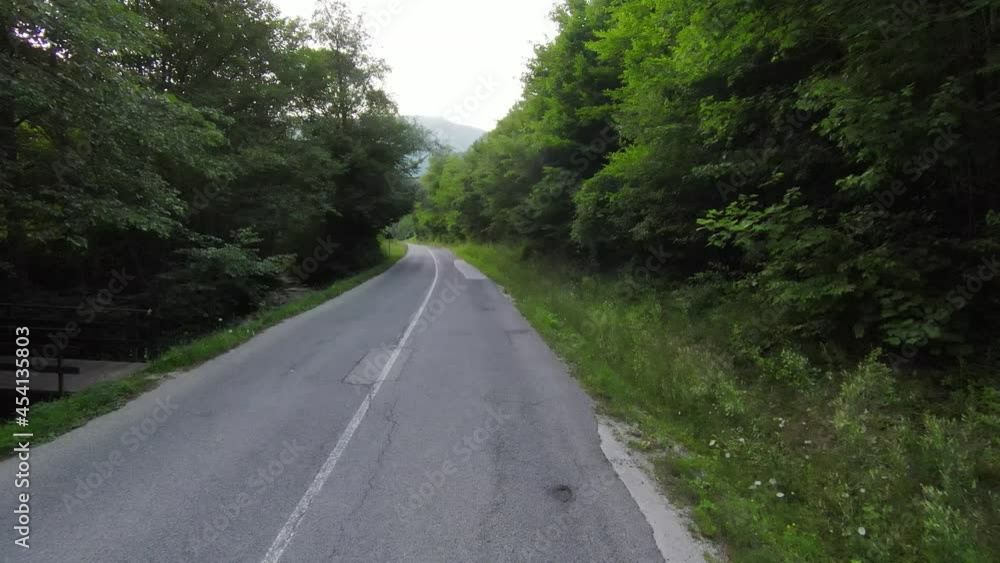 fallowing fpv aerial fast flying shot over a country road in the misty forest in the mountain. fallowing fpv aerial fast flying shot over a country road in the misty forest in the mountain.