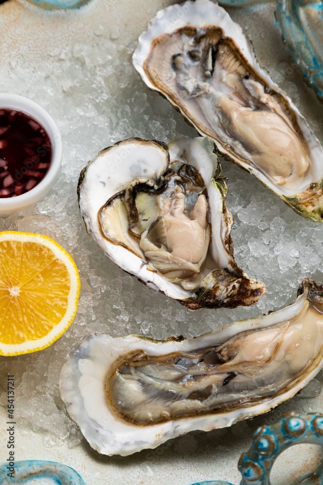 fresh open oysters with sauce, lemon and a glass of wine fresh open oysters with sauce, lemon and a glass of wine