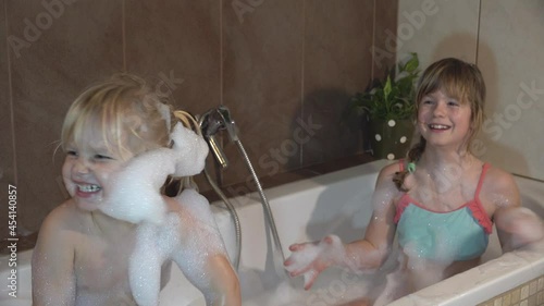 Fun games in the bathroom of the blonde sisters. Happy kids as they bathe