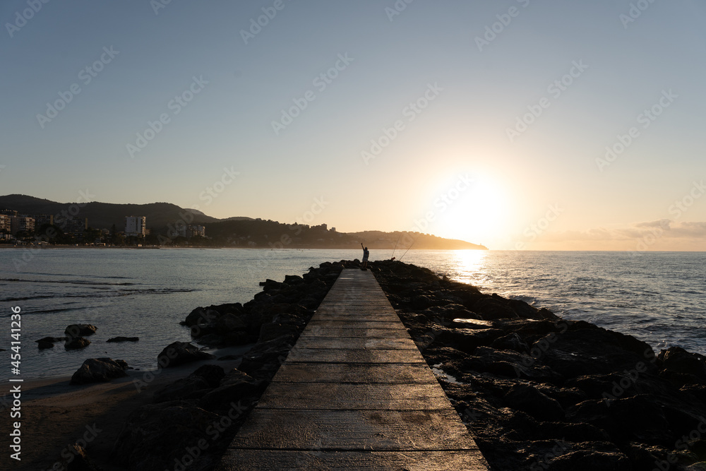 Fisherman saying hi fishing by the sea suring sunrise