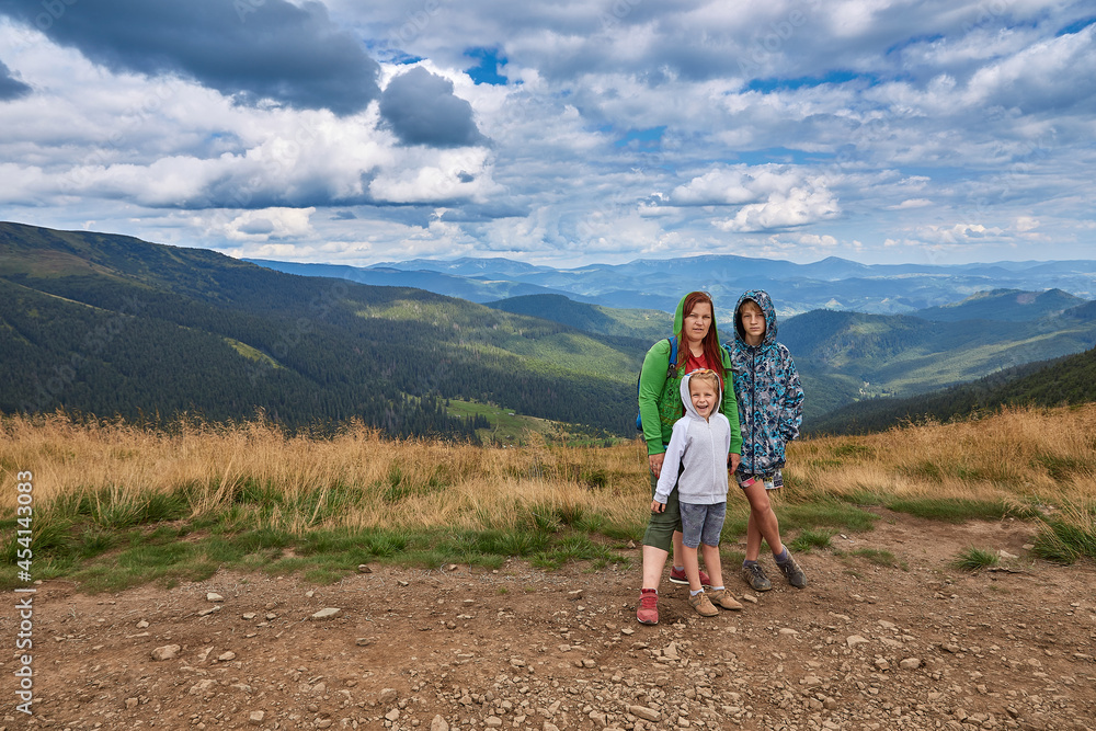 Portrait of mother with children on a background of mountains. A walk in nature.