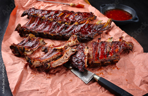 Barbecue pork spare loin ribs St Louis cut with hot honey chili marinade served as close-up on butcher paper