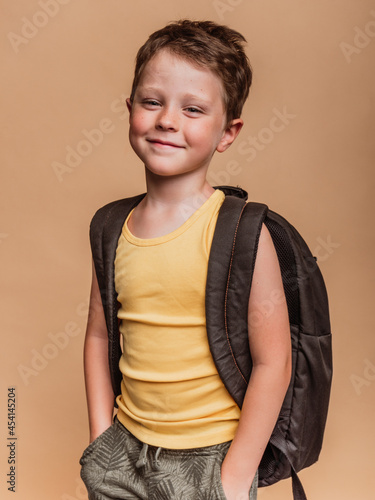 Smiling pupil with backpack in studio