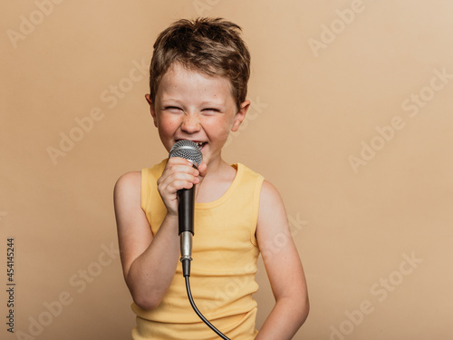 Preteen boy singing in microphone in studio