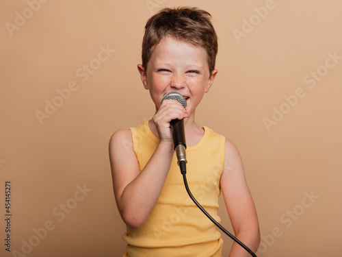 Preteen boy singing in microphone in studio