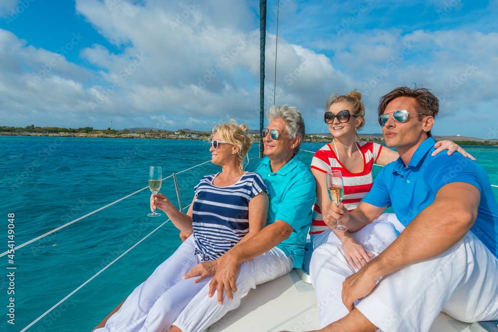 Senior and young couples, family, enjoying sailing trip on a luxury summer holiday vacation, sunny weather and ocean in background, love and romance on a beautiful yacht