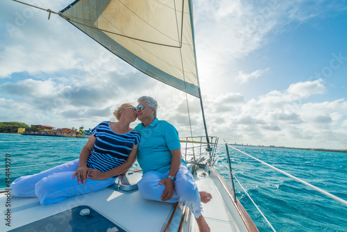 Senior couple enjoying sailing trip on a luxury summer holiday vacation, sunny weather and ocean in background, love and romance on a beautiful yacht