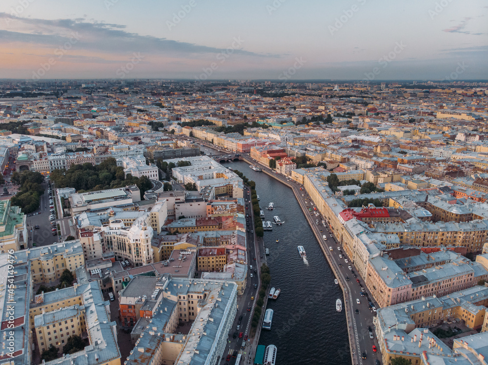 Sunset aerial view on Fontanka river and old houses in center of St Petersburg. Colorful rooftops. Boats float on the water. Russia in the summer. Place for vacation. Nevsky prospect on background.