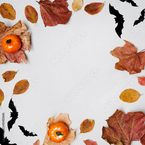 Halloween background with copy space. Frame made of Halloween decorations and dried autumn leaves. 