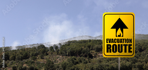 Cartel de alto riesgo de incendio con incendio forestal de fondo. Evacuation route sign with forest fire. Warning. Alert. Copy space. Banner.