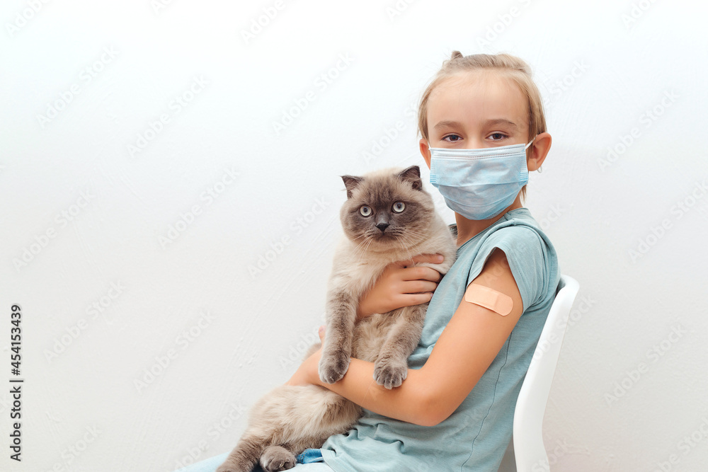 Boy with cat sitting at chair after vaccine. Kid vaccinated against coronavirus infection. Boy with cat sitting at chair after vaccine. Kid vaccinated against coronavirus infection.