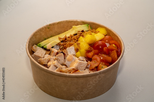 Top view of poke bowl with salmon and avocado on white background 