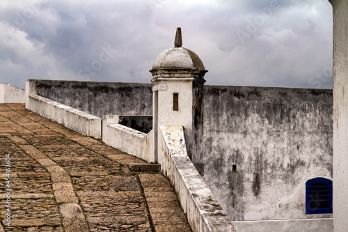 A bulwark of the fortress of Santa Cruz da Barra, in the city of Niterói, Brazil. Portuguese construction of the XVI Century. A road through a historic city on a cloudy day.