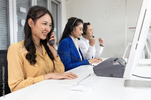 woman operator pick up telephone and talking with customer at call center service