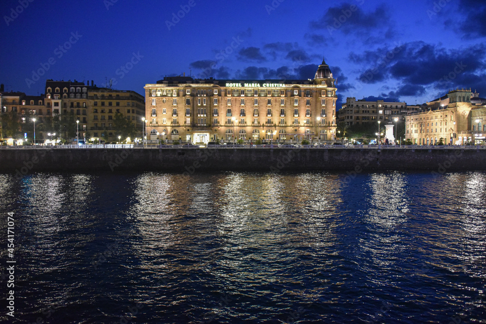 San Sebastian, Spain - 29 Aug 2021: Hotel Maria Cristina illuminated on the banks of the Urumea River