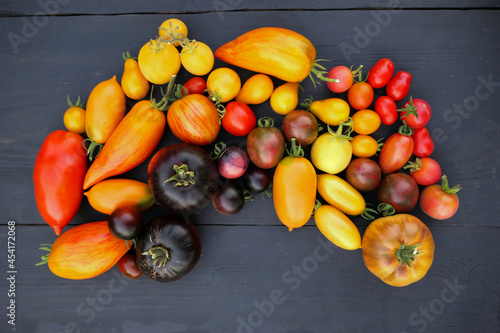 Heirloom tomatoes collection on black wooden background.