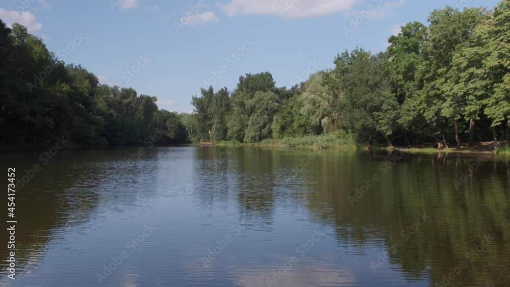Pond with green water among lawns and trees against buildings of city. Pond with green water among lawns and trees against buildings of city.