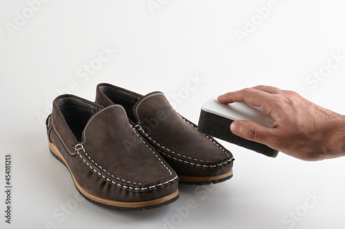 Man hand cleaning his shoes with polishing shoe sponge