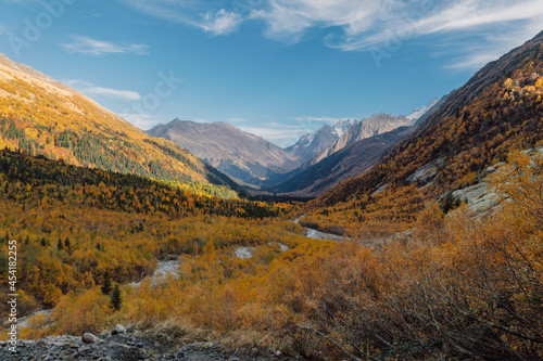 Valley with mountains and autumnal forest. Mountain landscape with river