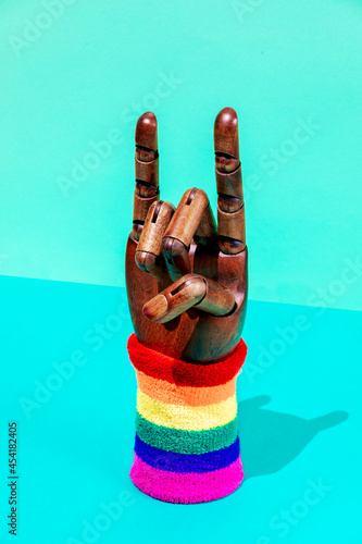 Hand with horn gesture and LGBTQ ornament on wristband