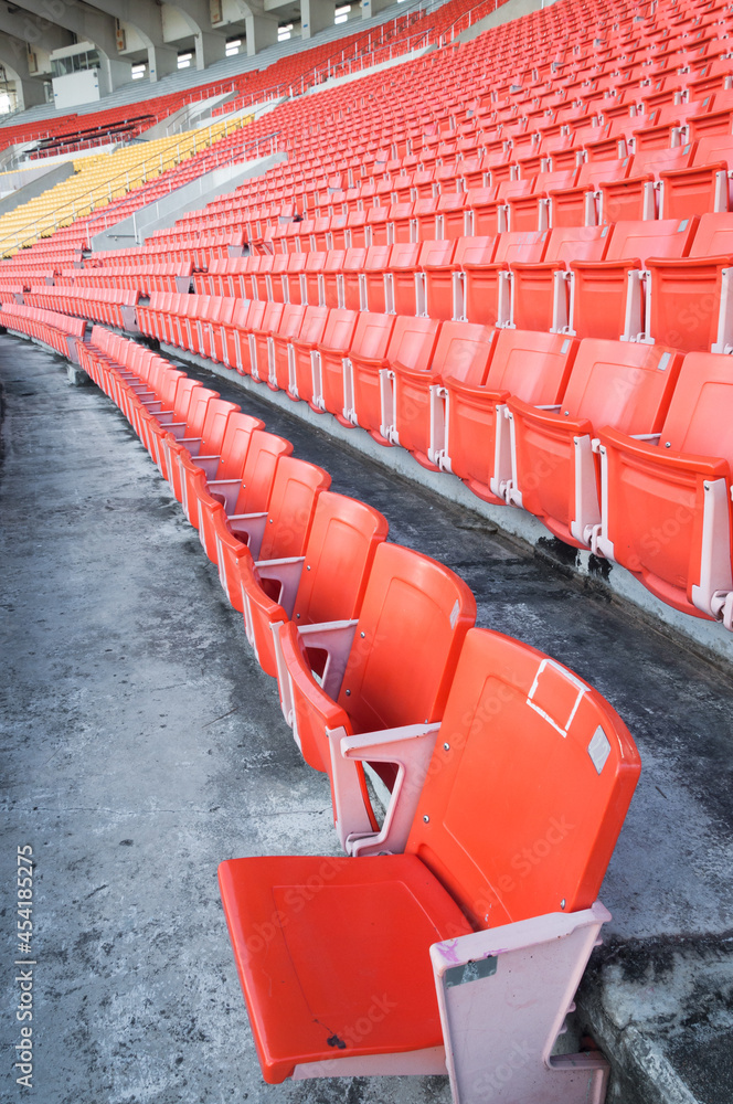 Fototapeta premium Empty orange seats at stadium,Rows walkway of seat on a soccer stadium